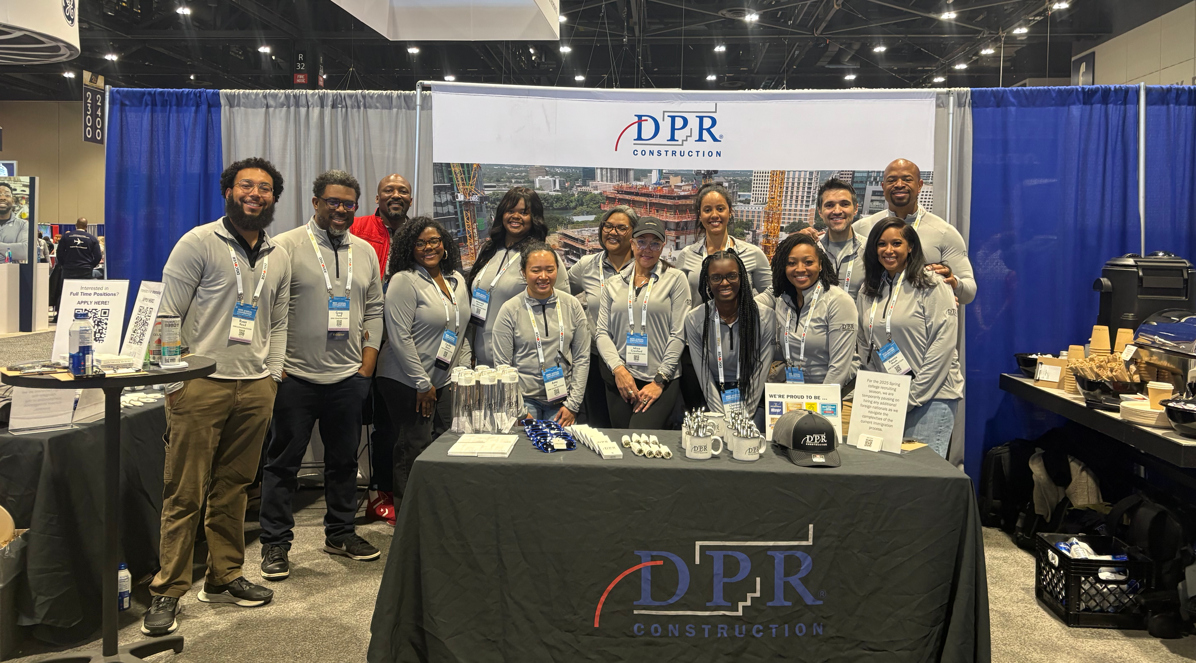 group of employees standing at a table in the DPR booth at a recruiting event